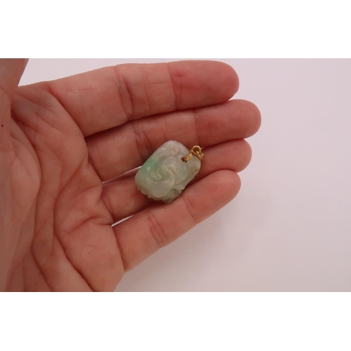 43 - A carved jade pendant. Length 20mm. Pendant fitting stamped 18K. Weight 8.71 grams