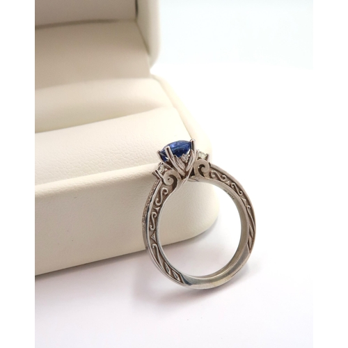 9 - A 10ct gold Round Sapphire & Diamond ring. Diamond set shoulders and intricately designed side setti... 