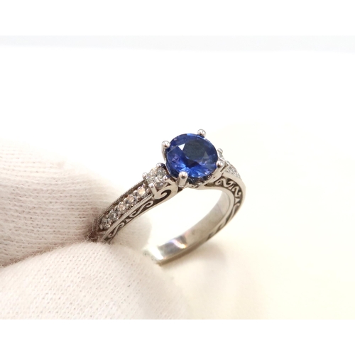 9 - A 10ct gold Round Sapphire & Diamond ring. Diamond set shoulders and intricately designed side setti... 