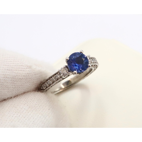 9 - A 10ct gold Round Sapphire & Diamond ring. Diamond set shoulders and intricately designed side setti... 