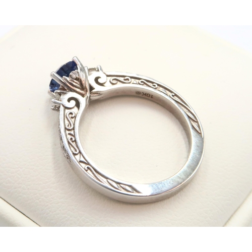 9 - A 10ct gold Round Sapphire & Diamond ring. Diamond set shoulders and intricately designed side setti... 
