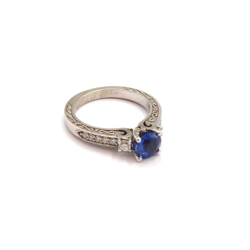 9 - A 10ct gold Round Sapphire & Diamond ring. Diamond set shoulders and intricately designed side setti... 