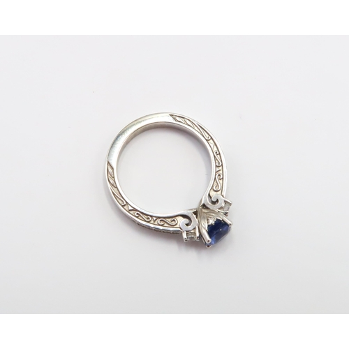 9 - A 10ct gold Round Sapphire & Diamond ring. Diamond set shoulders and intricately designed side setti... 