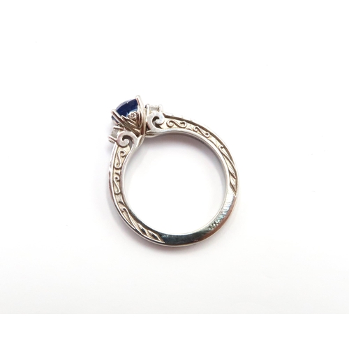 9 - A 10ct gold Round Sapphire & Diamond ring. Diamond set shoulders and intricately designed side setti... 