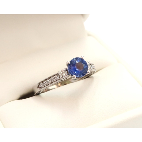 9 - A 10ct gold Round Sapphire & Diamond ring. Diamond set shoulders and intricately designed side setti... 