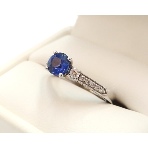 9 - A 10ct gold Round Sapphire & Diamond ring. Diamond set shoulders and intricately designed side setti... 