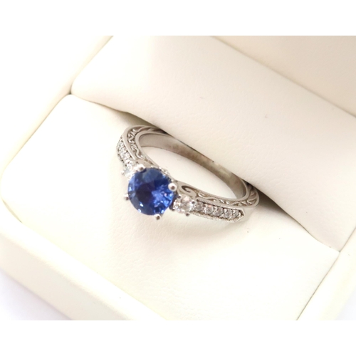 9 - A 10ct gold Round Sapphire & Diamond ring. Diamond set shoulders and intricately designed side setti... 
