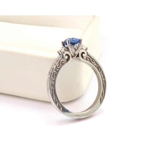 9 - A 10ct gold Round Sapphire & Diamond ring. Diamond set shoulders and intricately designed side setti... 