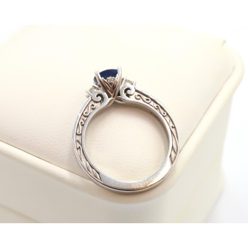 9 - A 10ct gold Round Sapphire & Diamond ring. Diamond set shoulders and intricately designed side setti... 