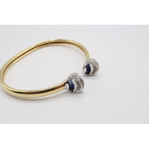 1 - An 18ct Gold Sapphire & Diamond Torque, ends individually set with tapered baguette sapphires with r... 