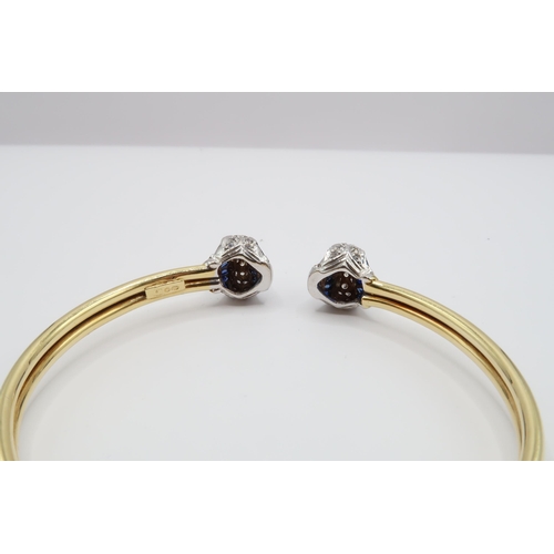 1 - An 18ct Gold Sapphire & Diamond Torque, ends individually set with tapered baguette sapphires with r... 