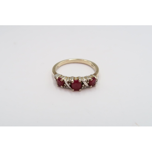 18 - A 9ct gold three stone ruby ring with diamond highlights. Size N 1/2. Weight 2.83 grams