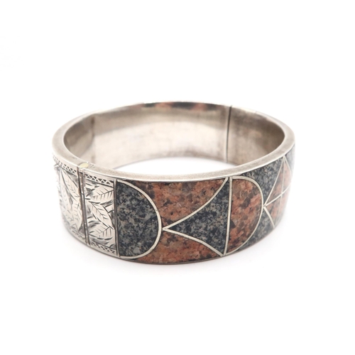 69 - An Early 20th Century Silver and Granite inlaid bangle. 

Weight: 35.8g