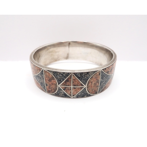 69 - An Early 20th Century Silver and Granite inlaid bangle. 

Weight: 35.8g