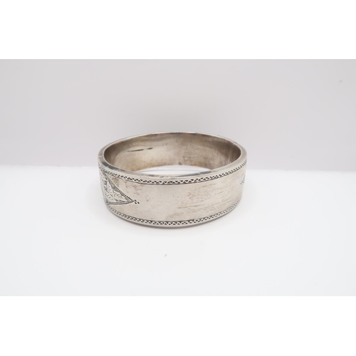 69 - An Early 20th Century Silver and Granite inlaid bangle. 

Weight: 35.8g