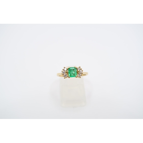 19 - An 18ct yellow gold (tested) emerald and diamond ring, emerald has natural inclusions, diamonds brig... 