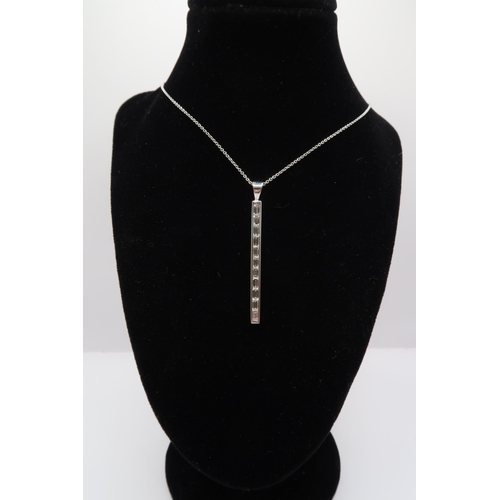 57 - An 18ct gold baguette diamond line pendant. Length of pendant 40mm. Weight 3.62 grams