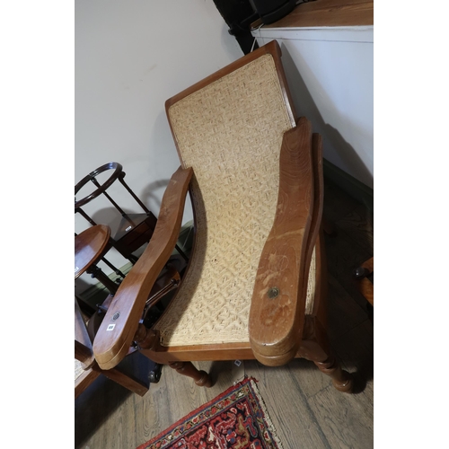 600 - An early 20th century cherry wood British Colonial Plantar's chair with woven cane curved seat, some... 