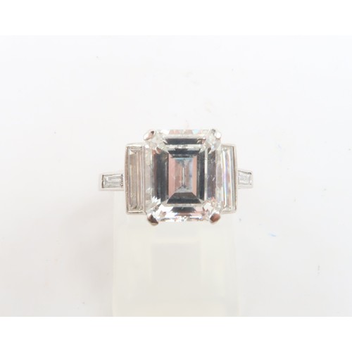 19 - A Deco Style Diamond Dress Ring - The central emerald cut diamond with a vertical baguette to each s... 