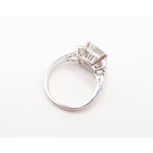 19 - A Deco Style Diamond Dress Ring - The central emerald cut diamond with a vertical baguette to each s... 