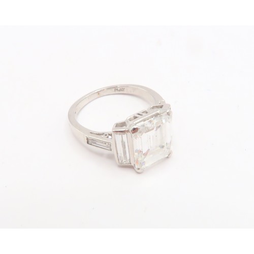19 - A Deco Style Diamond Dress Ring - The central emerald cut diamond with a vertical baguette to each s... 