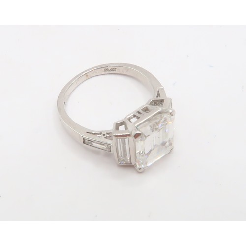 19 - A Deco Style Diamond Dress Ring - The central emerald cut diamond with a vertical baguette to each s... 