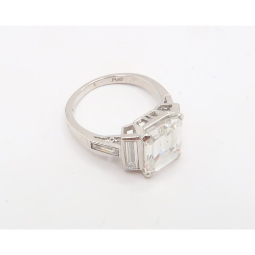 19 - A Deco Style Diamond Dress Ring - The central emerald cut diamond with a vertical baguette to each s... 