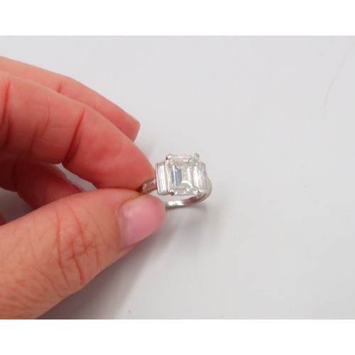 19 - A Deco Style Diamond Dress Ring - The central emerald cut diamond with a vertical baguette to each s... 