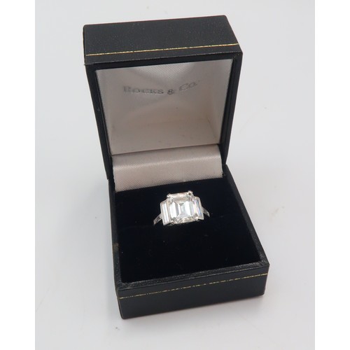 19 - A Deco Style Diamond Dress Ring - The central emerald cut diamond with a vertical baguette to each s... 