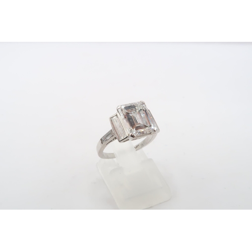 19 - A Deco Style Diamond Dress Ring - The central emerald cut diamond with a vertical baguette to each s... 