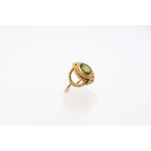 11 - A 9ct gold peridot single stone ring with ropetwist detail. Size O 1/2. Weight 4.60 grams