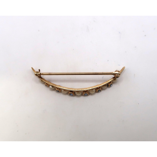 34 - A freshwater pearl and sapphire crescent brooch. Stamped 14K. Length 30mm. Weight 1.71 grams