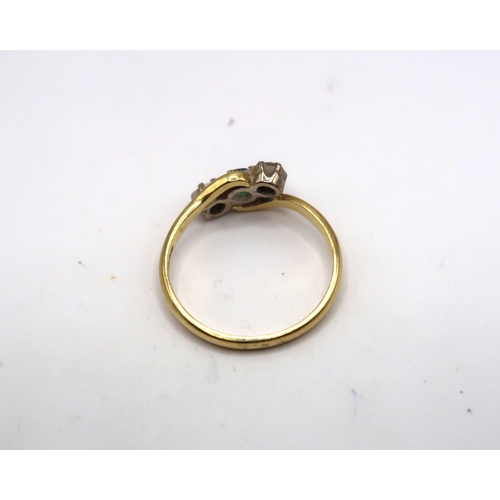 36 - An 18ct emerald and diamond three stone crossover ring. Size L 1/2. Weight 2.23 grams&nbsp;