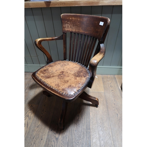 621 - A vintage Captain's swivel chair with slatted back and leather seat, on casters, 82cm high x 59cm wi... 