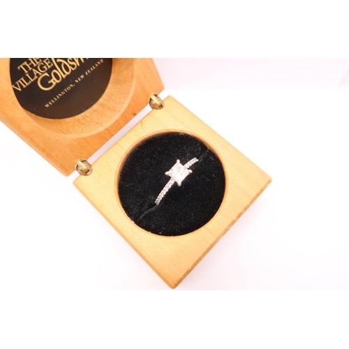  A princess cut diamond ring with brilliant cut diamonds to each shoulder. Estimated total diamond we... 