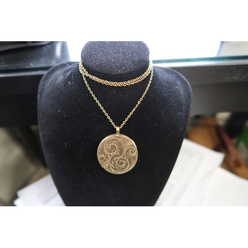  A 9ct gold circular locket, diameter 34mm. Suspended from a belcher link chain, tests 9ct. Weight 15... 