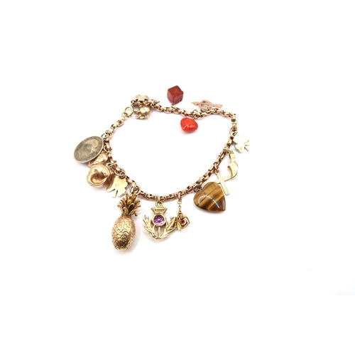 62 - A 9ct Gold Charm Bracelet Comprising of 15 Charms to include Cross, Shamrock, Pig, Silver threepence... 