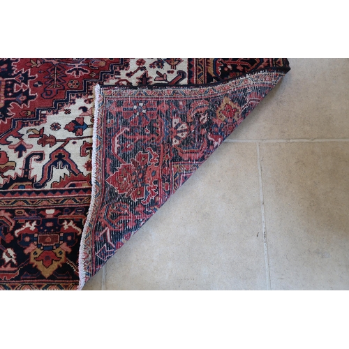 578 - A hand knotted woollen Persian Heriz rug - 3.45m x 2.60m