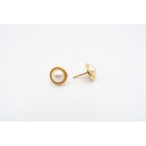 200 - A pair of 18ct gold half pearl ear studs. Weight 1.19 grams