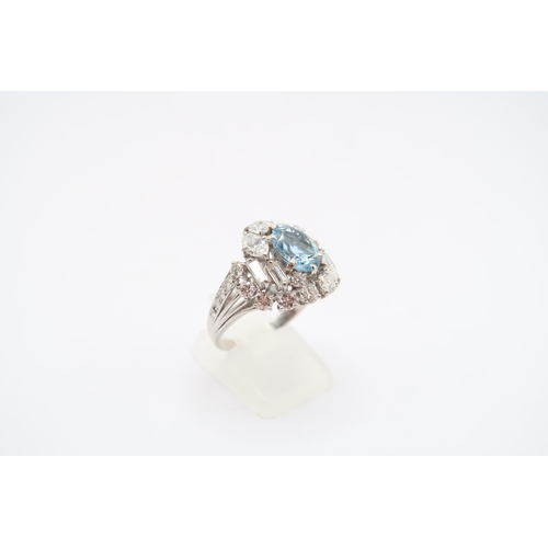 9 - An 18ct White Gold Aquamarine and Diamond Cluster Ring. Featuring a Raised Twist design with two mar... 