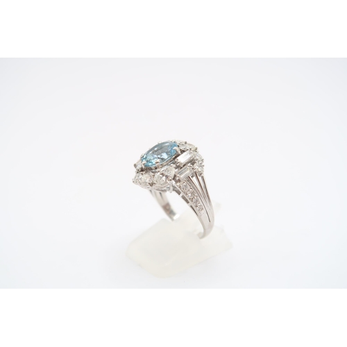 9 - An 18ct White Gold Aquamarine and Diamond Cluster Ring. Featuring a Raised Twist design with two mar... 