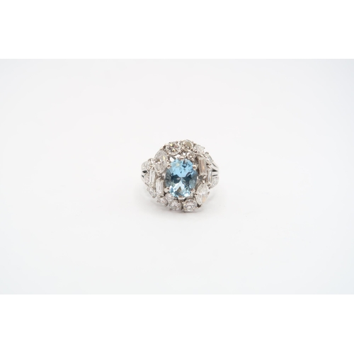 9 - An 18ct White Gold Aquamarine and Diamond Cluster Ring. Featuring a Raised Twist design with two mar... 