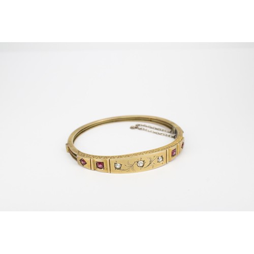 38 - An early 20th century ruby and diamond hinged bangle. Tests 8/9ct. Weight 11.70 grams(To Note: Viewi... 