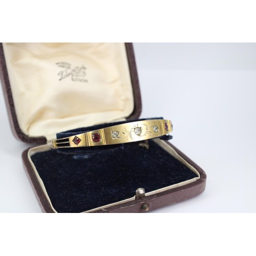 38 - An early 20th century ruby and diamond hinged bangle. Tests 8/9ct. Weight 11.70 grams(To Note: Viewi... 