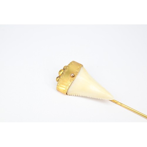 47 - A stick pin. Tests 14ct. Mounted with a shark&rsquo;s tooth. Weight 4.30 grams