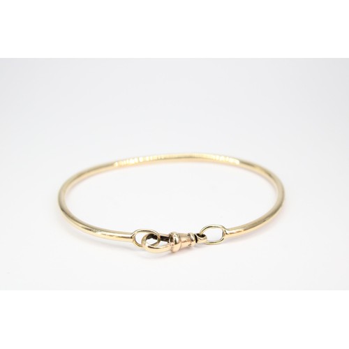 40 - A bangle with toggle clasp. Tests 9ct. Weight 10.10 grams, approx 6cm internal diameter