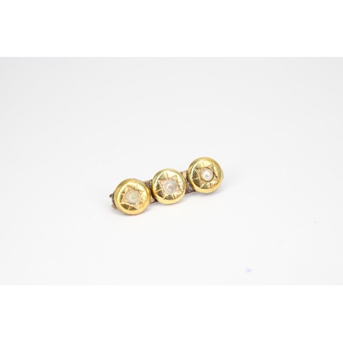 56 - A bar brooch set with three cultured pearls. Tests 18ct and 9ct metal pin. Weight 3.04 grams