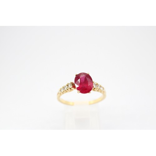61 - An oval ruby and graduated brilliant cut diamond ring. Stamped 750. Size Q 1/2. Weight 3.23 grams