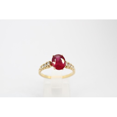 61 - An oval ruby and graduated brilliant cut diamond ring. Stamped 750. Size Q 1/2. Weight 3.23 grams