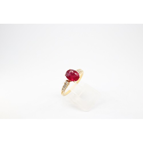 61 - An oval ruby and graduated brilliant cut diamond ring. Stamped 750. Size Q 1/2. Weight 3.23 grams